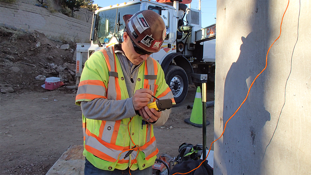 A man uses the COMMAND Center™ Trimble Nomad to view concrete temperature and strength data.